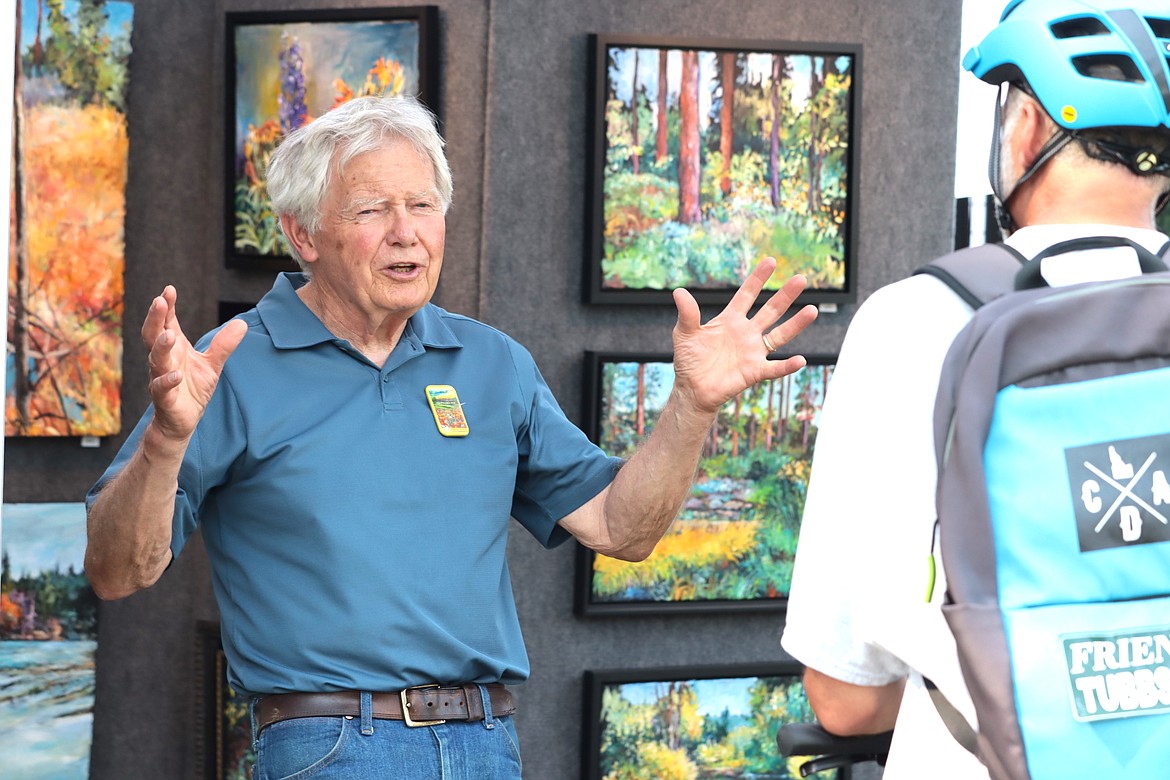 LR Montgomery chats with a visitor to his art booth at Art on the Green on Friday.