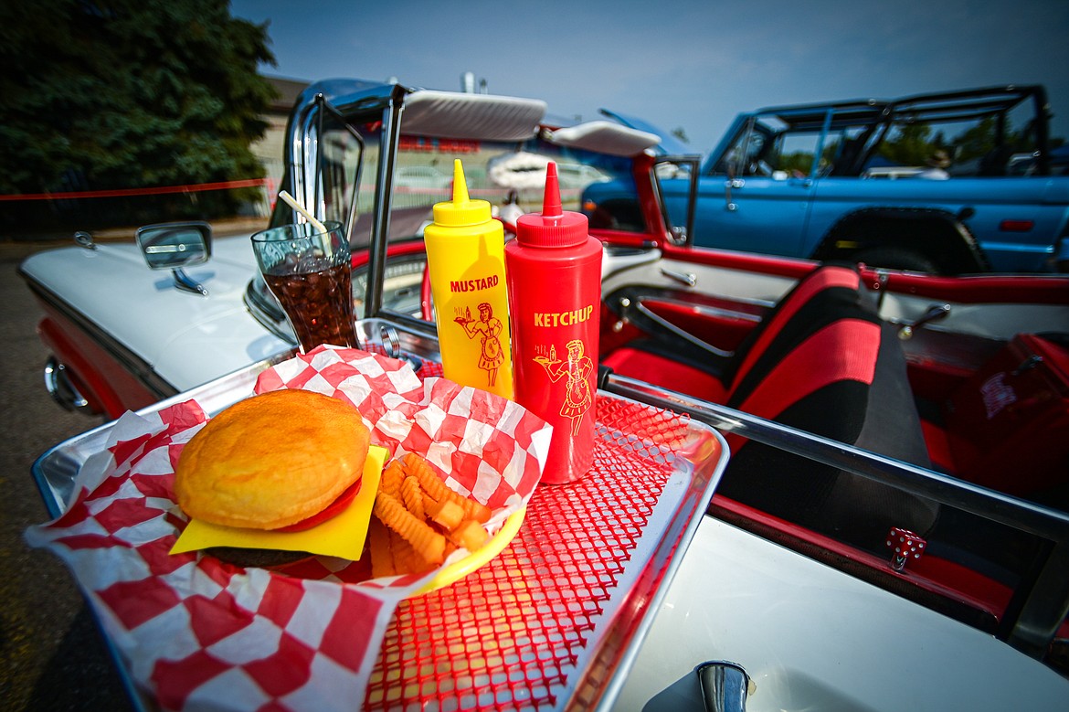 A drive-in tray with a decorative cheeseburger, condiments and soda hang from the window of a 1959 Ford Galaxie at the Evergreen Show 'N Shine at Conlin's Furniture on Saturday, Aug. 3. (Casey Kreider/Daily Inter Lake)