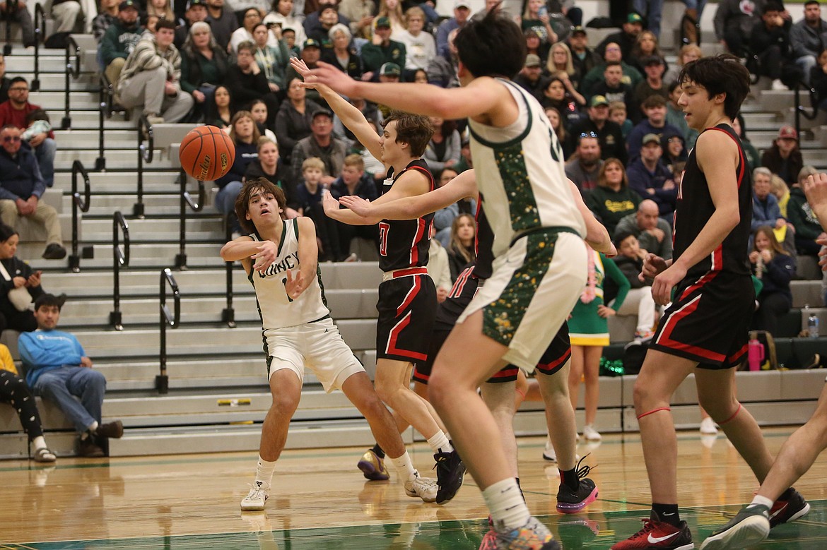 Quincy’s Pierce Bierlink, left, passes the ball to a teammate during a game against Omak this past season. Bierlink won the Caribou Trail League’s most valuable player award this winter.