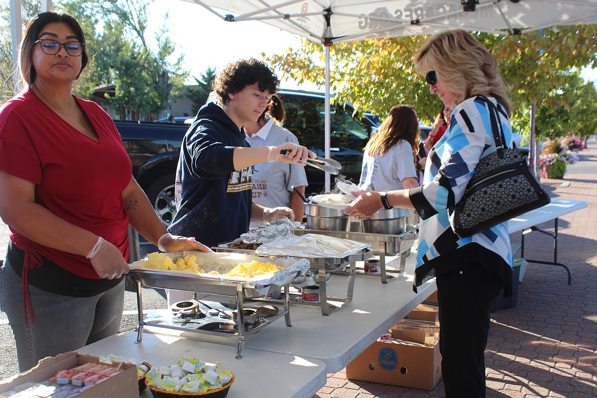 Volunteers man the chow line at the Cowboy Breakfast last year. This year’s breakfast is Friday.