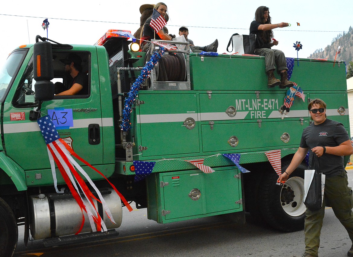 Superior graduate, Jaxson Green walks along a Forest Service truck tossing candy. (Mineral Independent/Amy Quinlivan)