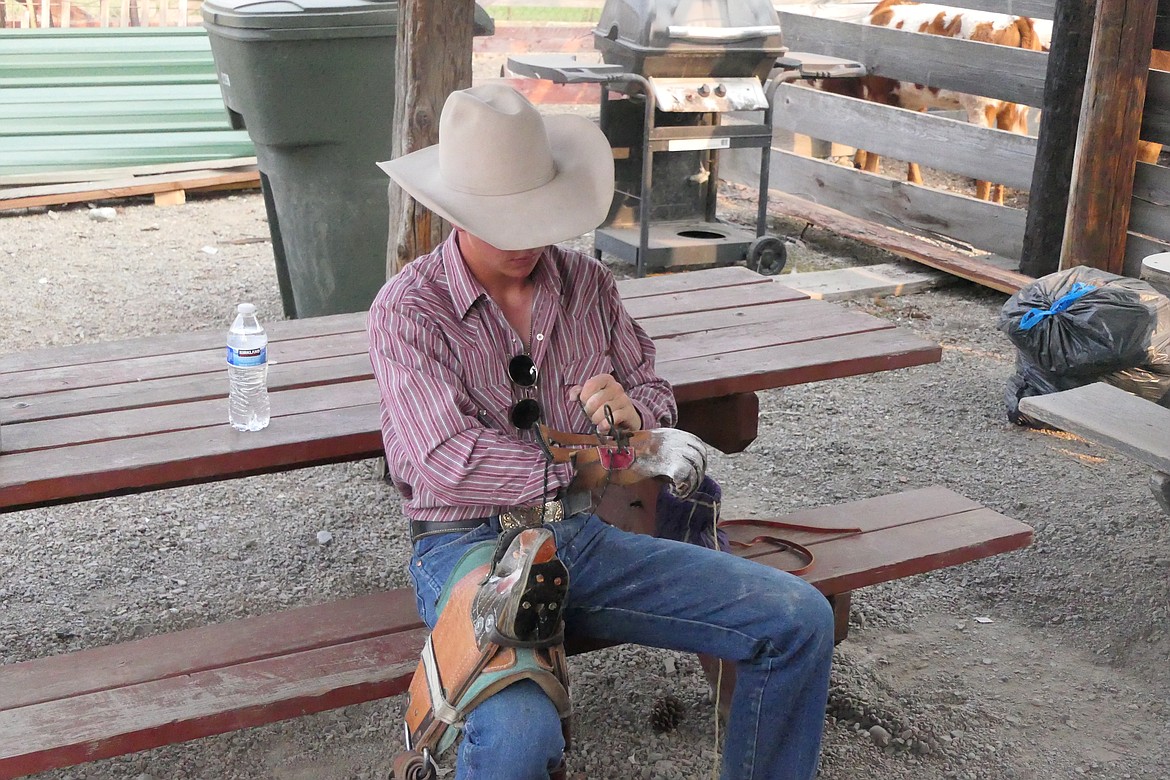 Great Falls bareback bronc rider Wyatt Warneke tapes up in preparation for his ride Friday night during the Superior Lions Club rodeo.  (Chuck Bandel/VP-MI)