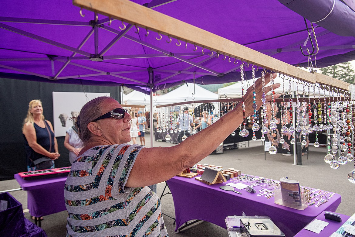 Starla Saucier  of Montana Star Creations arranges suncatchers in her booth at Festival of the Arts Saturday, August 3. (Avery Howe/Bigfork Eagle)