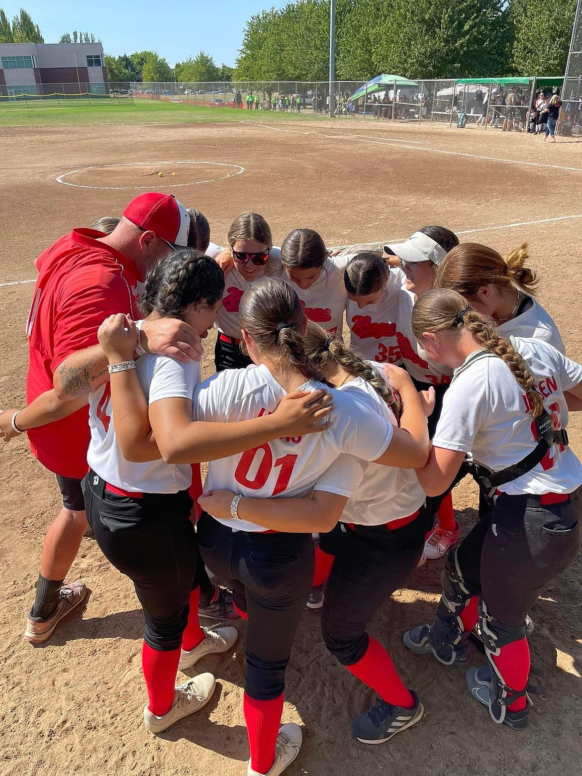 Players and coaches for the 14U Washington Rage huddle up before a game at last weekend’s NAFA Summer Nationals in Newberg, Oregon.