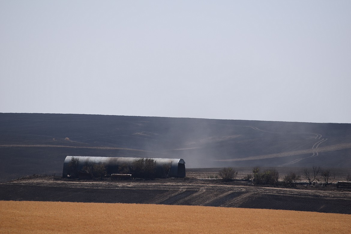 While no buildings were lost, this equipment barn near Coulee City was singed by the wheat field fire near Coulee City Tuesday. More than 350 acres of crops were destroyed by the blaze.