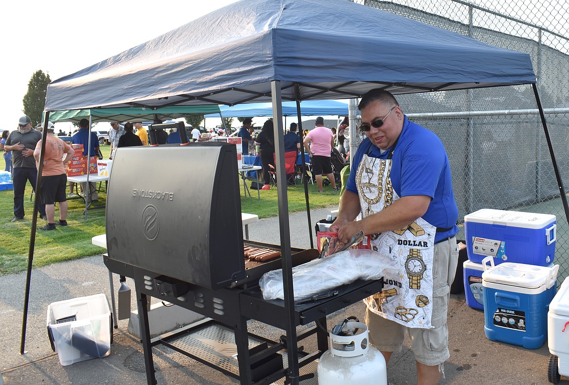 Quincy Police Officer Alan Talbot tries to grill enough hot dogs to keep up with the demand at National Night Out in Quincy Monday. About 500 people attended the event, which included free hot dogs and ice cream.