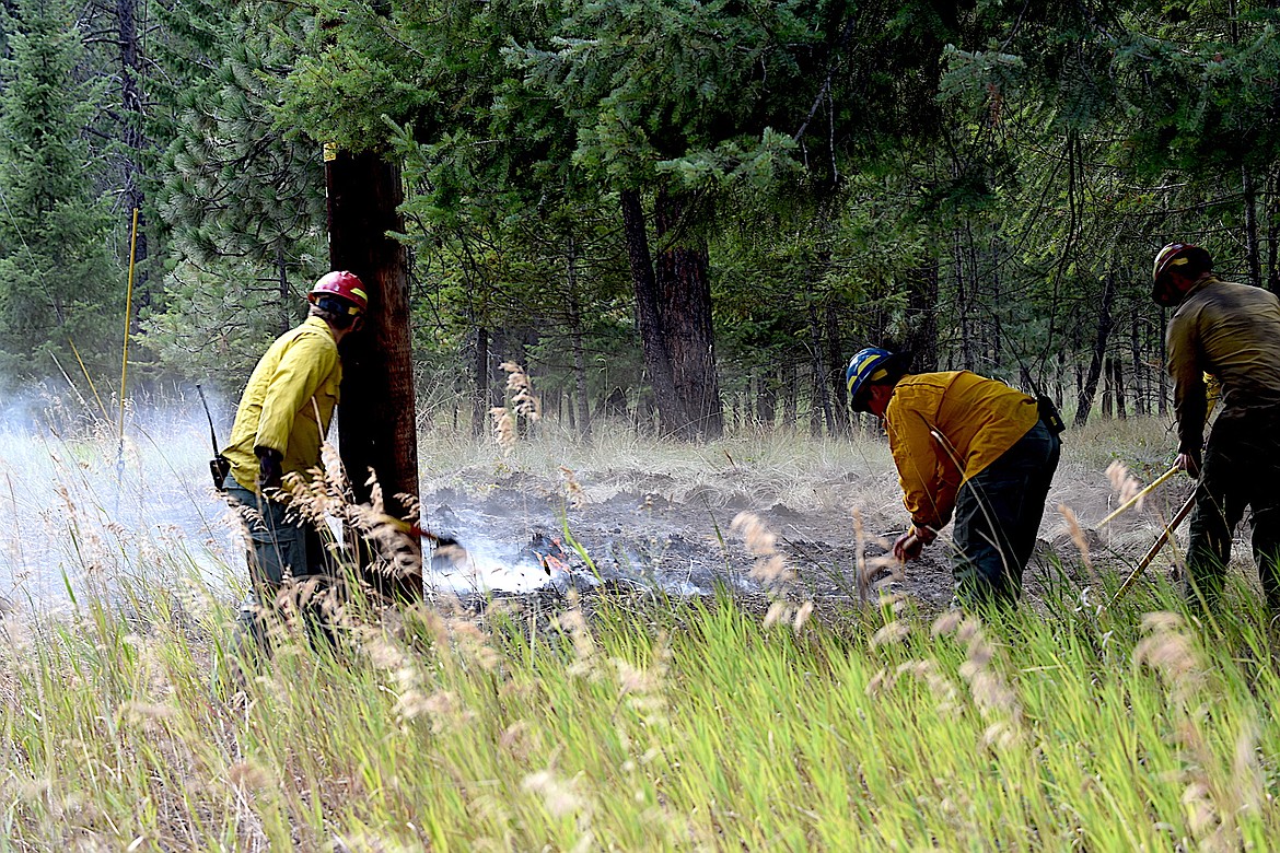 Kootenai National Forest fire fighters dig a line around a small fire early Wednesday evening on Rawlings Road just outside Libby. (Scott Shindledecker/The Western News)