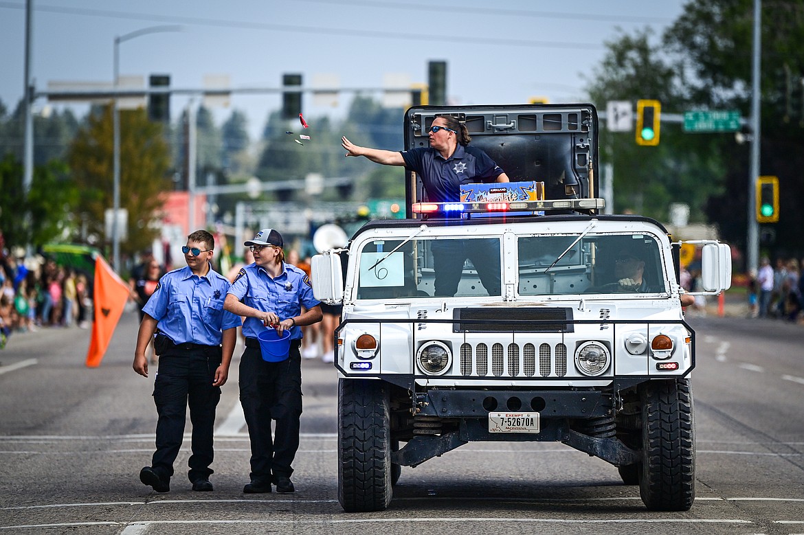 Paula Sullivan with the Flathead County Sheriff's Office tosses candy to kids during the Northwest Montana Fair Parade in Kalispell on Friday, Aug. 9. (Casey Kreider/Daily Inter Lake)