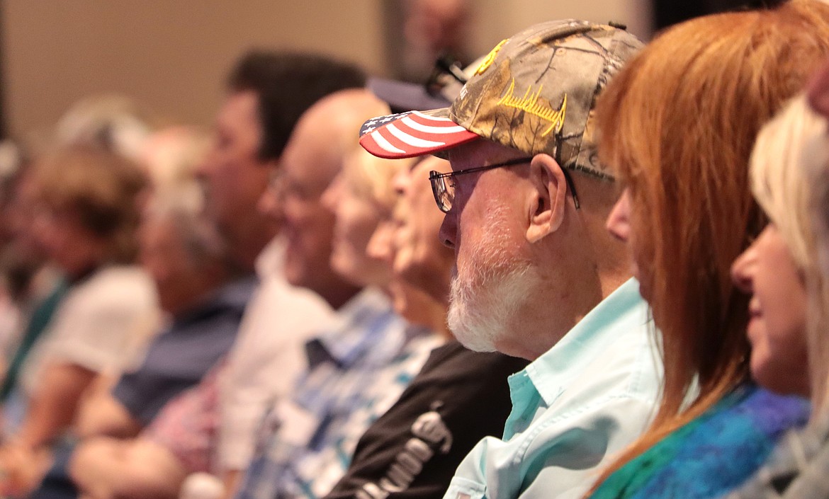 A man wearing a red, white and blue cap listens to Congressman Jim Jordan speak at Candlelight Christian Fellowship on Friday.