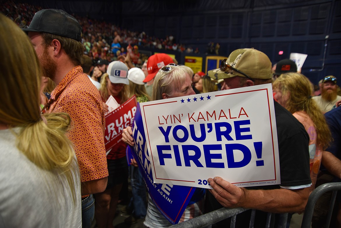 A couple holds at sign at a rally for former President Donald Trump on Aug. 9, 2024 in Bozeman. (Kate Heston/Daily Inter Lake)