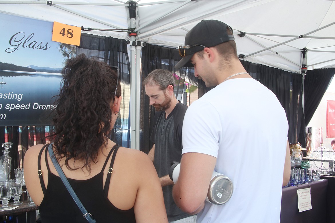 Evan Schaefer helps customers at the Priest Lake Art & Glass booth, a "functional art" business he owns with his wife, Cassie.