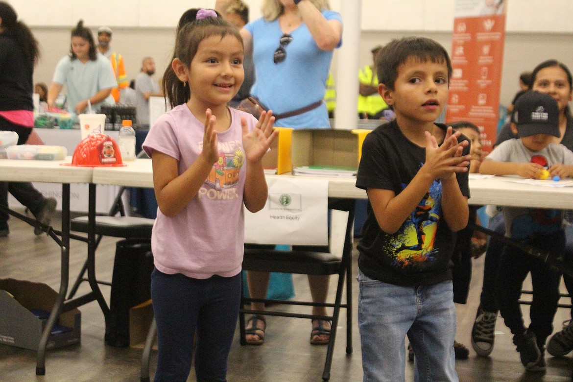 Children clap along during the chicken dance at the Back to School Health Fair in Quincy.