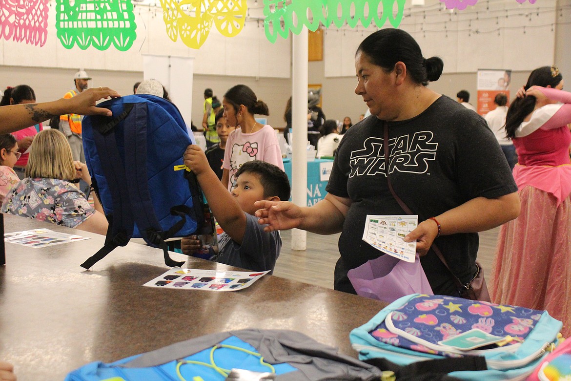 A Quincy student gets a new backpack during the back-to-school health fair.