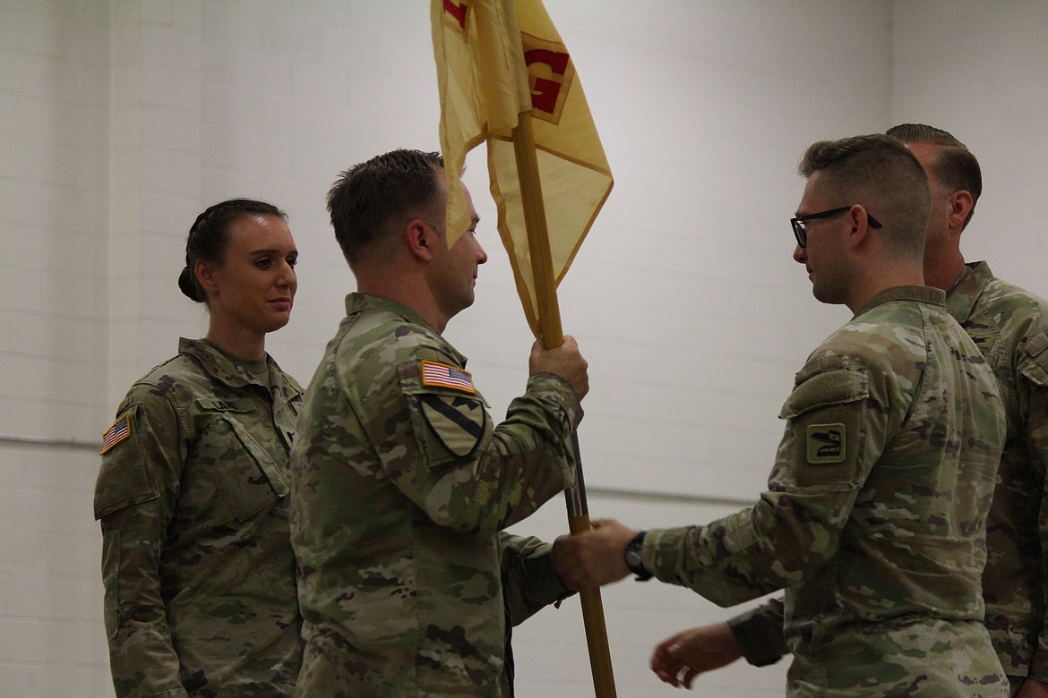 With the exchange of the company emblem, command moves from Capt. Charles Barnett, right, to Capt. Georgia Lamb, left.