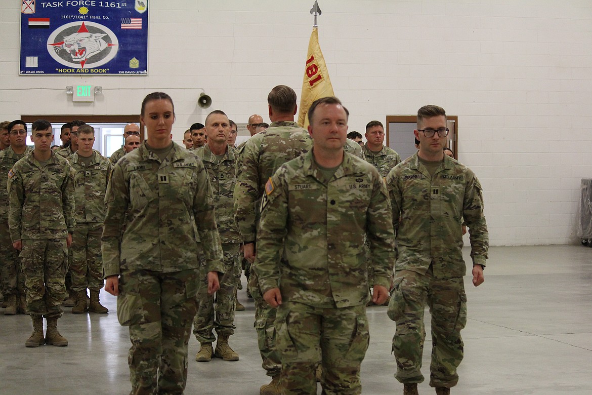 Battalion commander Lt. Col. Nick Stewart, center, leads incoming Golf Company commander Capt. Georgia Lamb, and outgoing commander Capt. Charles Barnett back to their seats after the change of command.