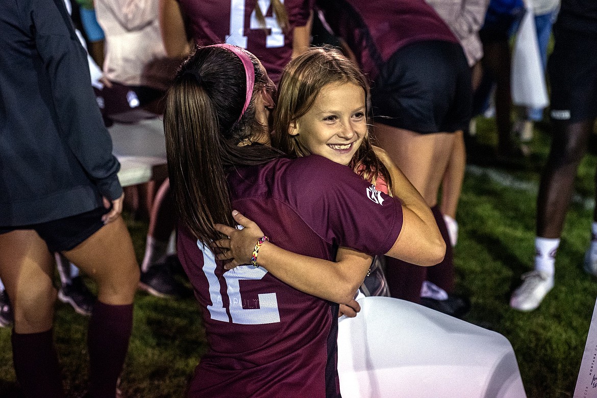 Paisley Sheldon of Kalispell gets a hug and an autograph from Grizzly Erin Ewers after the Gonzaga-Montana exhibition game in Columbia Falls Sunday, August 11. (Avery Howe/Bigfork Eagle)