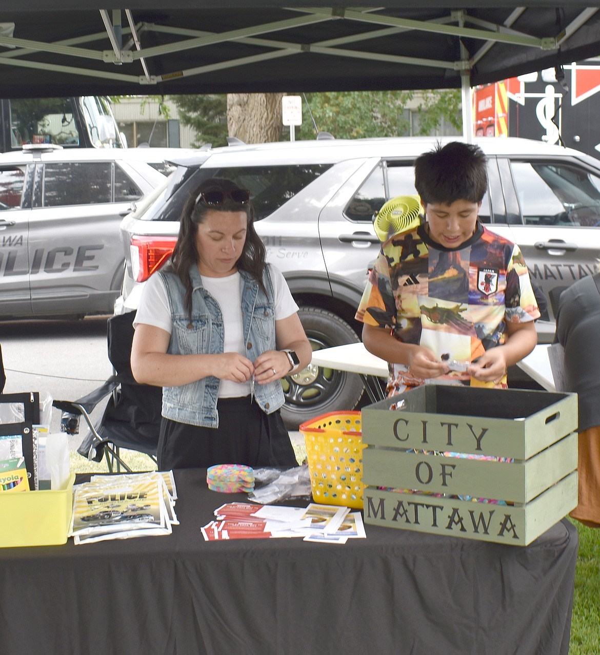 Erika Lopez, left, and Ektor Lopez put together prize packets for children at National Night Out in Mattawa Friday.