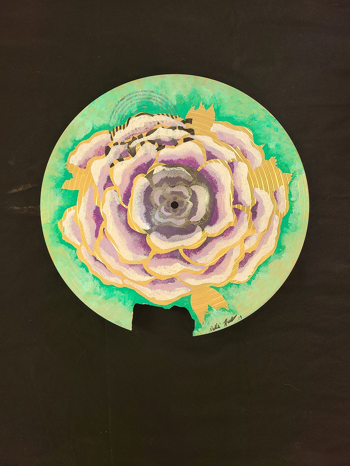 One of Nellie Hoot’s favorite painting surfaces is cymbals from her husband’s drum set. Here she used masking tape and oil paint to create a flower on a broken cymbal.