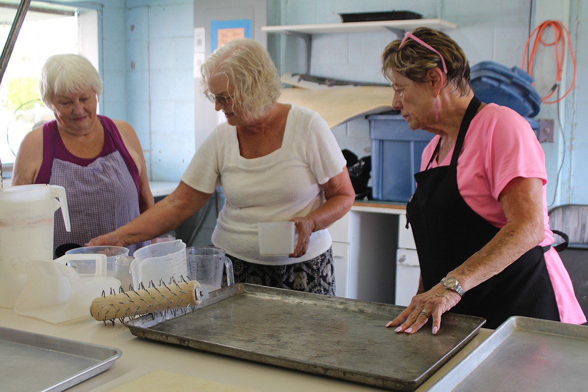 From left: volunteers Pat Simmons, Susan Hickok and Bonnie Webb unearth the tools they need for lion ears from the many cupboards and drawers in the Moses Lake Lions Club booth at the Grant County Fairgrounds. The fair opens today.