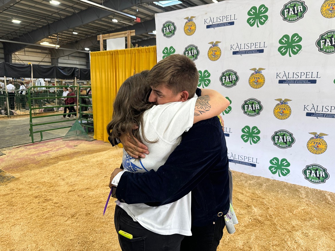 Manny Barone is hugged by a family friend after winning grand champion in the senior division of the hog showmanship competition Monday, Aug. 12 at the Northwest Montana Fair. (Hilary Matheson/Daily Inter Lake)