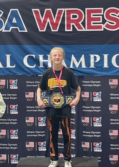 Ella Heyne earns a belt buckle on top of the podium at the Women’s National Tournament in Spokane, WA earlier this year. (Photo provided by Carly Sather-Heyne)