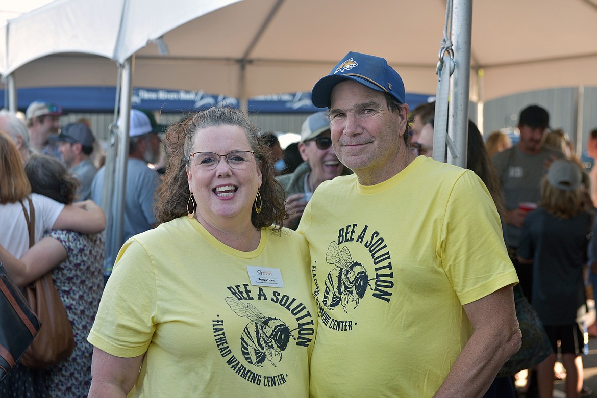 Tonya Horn and Luke Heffernan representing the Flathead Warming Center wear "bee a solution" t-shirts at the 10th annual Great Fish Community Challenge launch party Thursday. (Kelsey Evans/Whitefish Pilot)