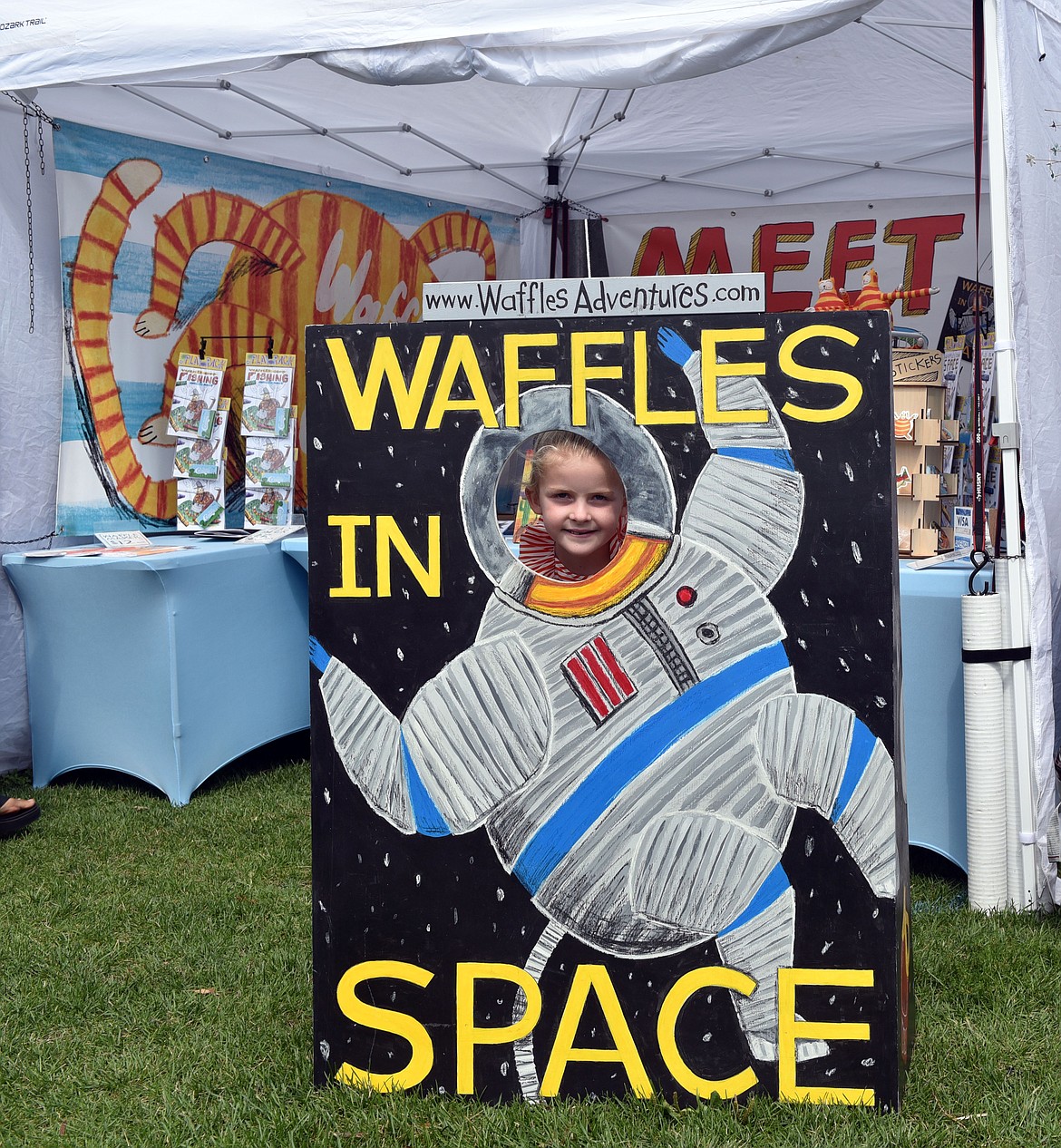 Annie Peck from Whitefish poses with the ‘waffles in space’ poster created by Nick Mask. Mask is based in southwest Montana and is the author/illustrator of the Waffles the Adventure Cat children's books. (Kelsey Evans/Whitefish Pilot)