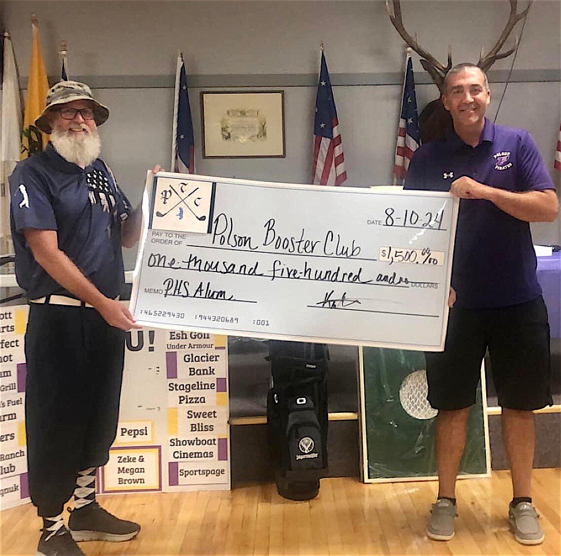 Kris McKethen, organizer of the P-Town Classic, hands Polson alum and PHS Principal Andy Fohrs a check for $1,500 at the close of this year's inaugural alumnus, faculty golf scramble.