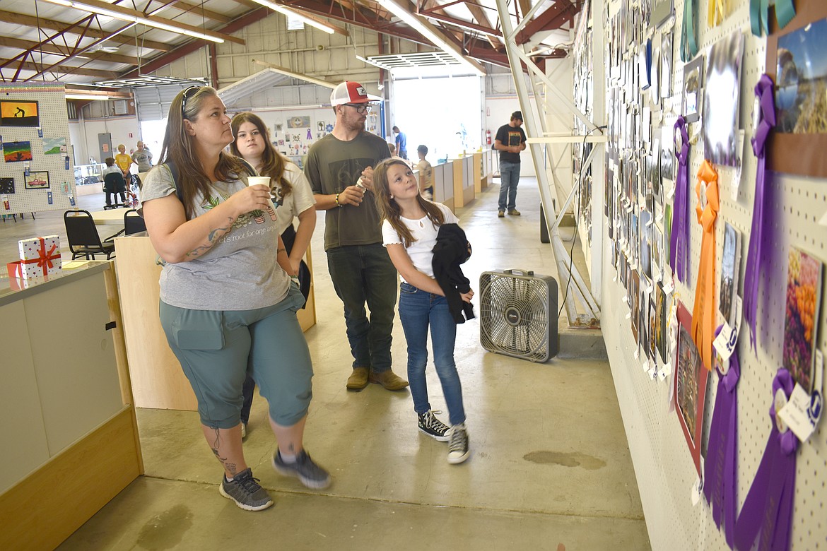 From left: Royalanne Hector, 12-year-old Jillian Hector, Braydon Hector and 9-year-old Lila Hector check out photographs in the Arts & Crafts Building at the Grant Count Fair Wednesday.