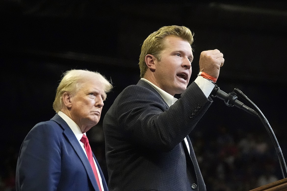 Republican presidential nominee former President Donald Trump listens as Montana Senate candidate Tim Sheehy speaks at a campaign rally in Bozeman, Mont., Friday, Aug. 9, 2024. (AP Photo/Rick Bowmer)