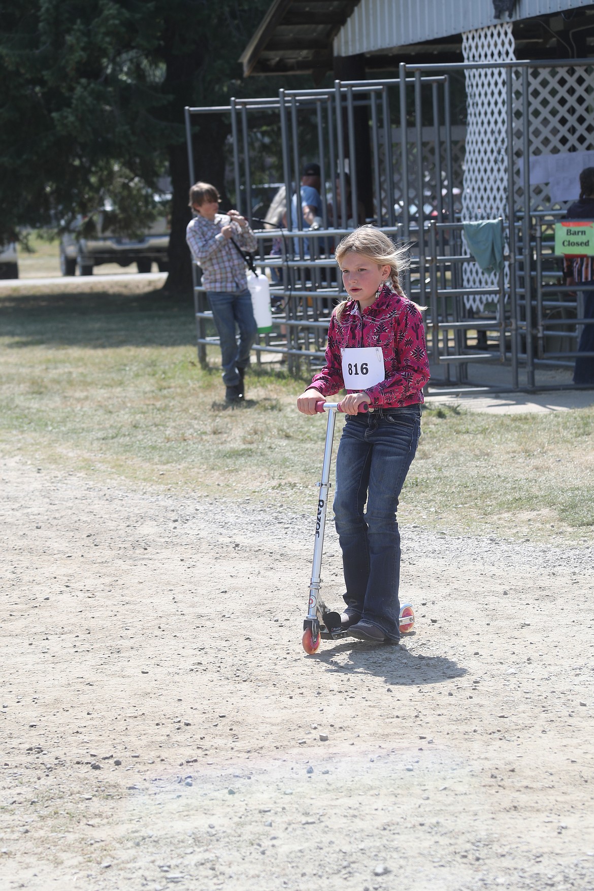 Olivia DaVault rides a scooter to get around the Bonner County Fairgrounds on Wednesday.