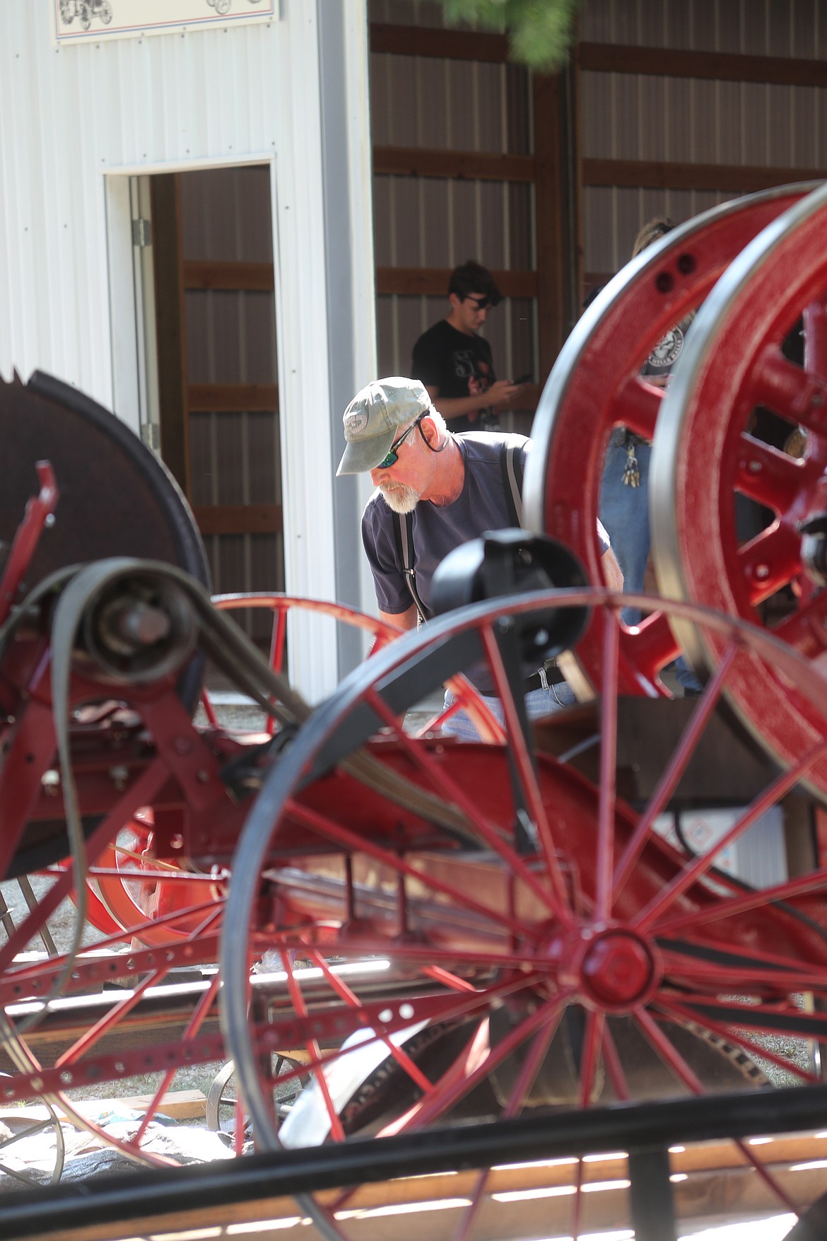 Marlin Turinsky runs a 1920 corn grinder at the Bonner County Fair on Wednesday. The machinery is one of dozens of vintage and antique tractors and machines being kept alive by the Panhandle Antique Tractor & Engine Club.