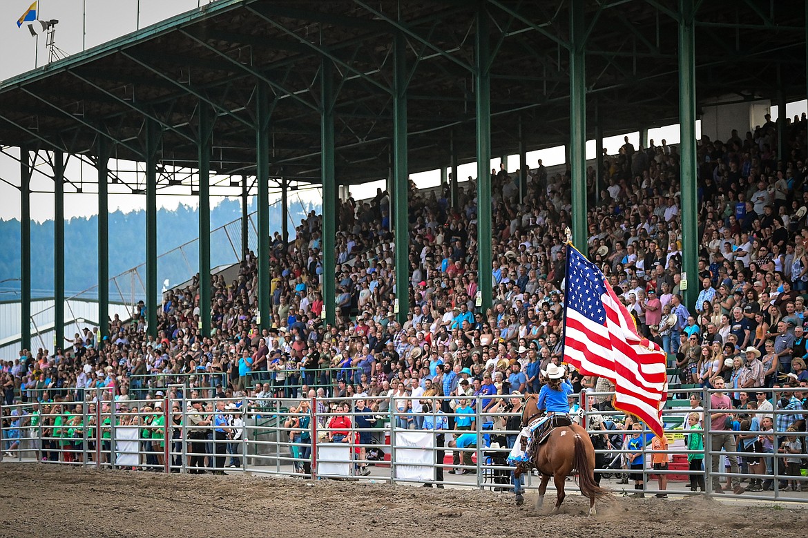 Attendees in the grandstands sing the national anthem during the opening ceremonies of the PRCA Rodeo at the Northwest Montana Fair & Rodeo on Thursday, Aug. 15. (Casey Kreider/Daily Inter Lake)