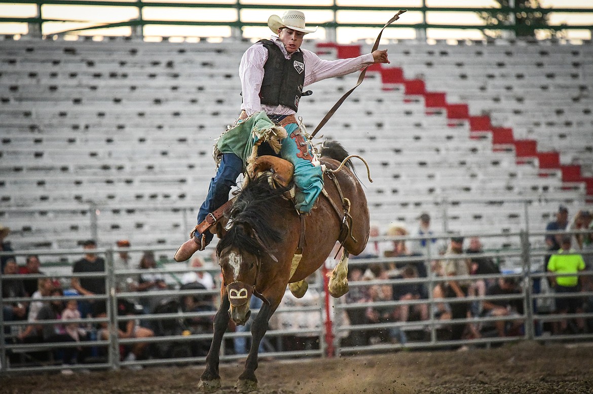 Kolby Kittson, from Browning, hangs onto his horse Extra Special during saddle bronc riding during the PRCA Rodeo at the Northwest Montana Fair & Rodeo on Thursday, Aug. 15. (Casey Kreider/Daily Inter Lake)