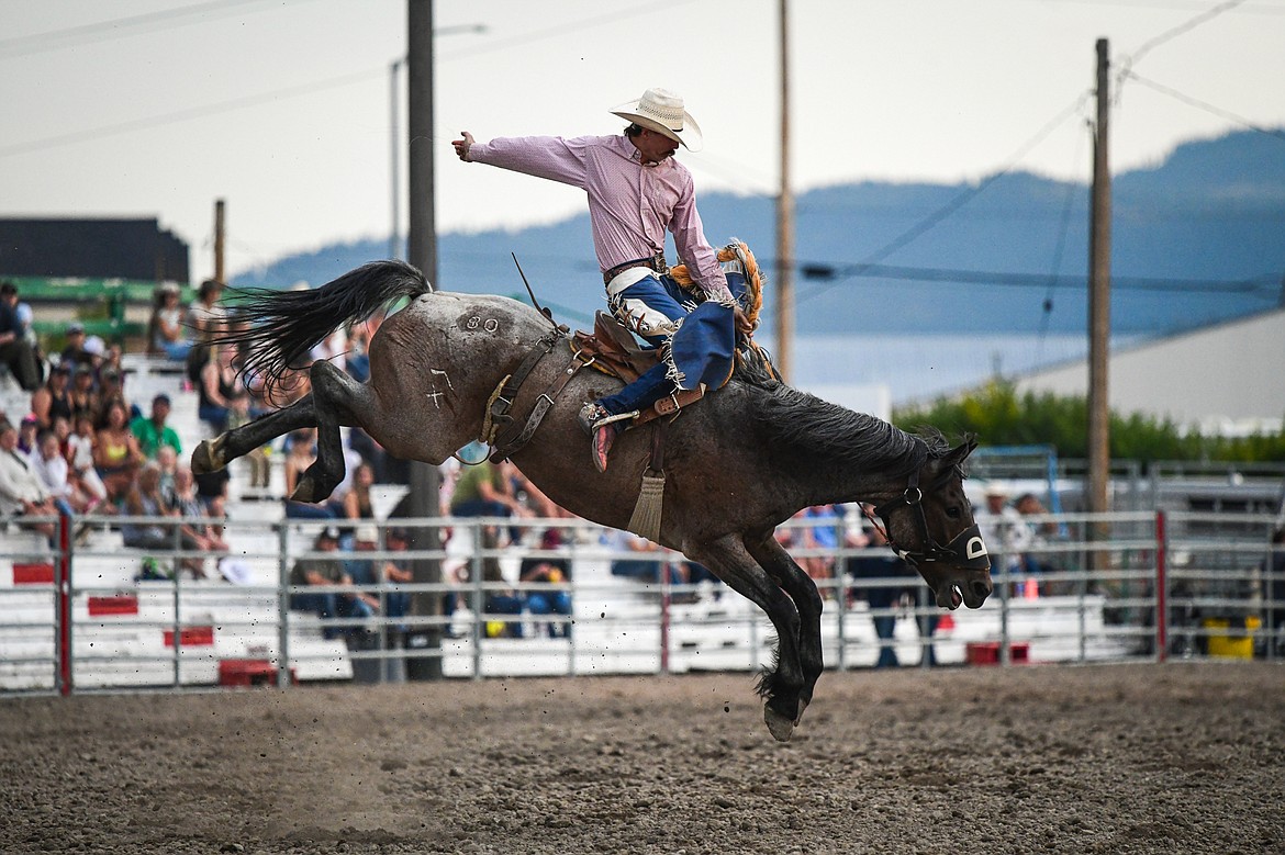 Bailey Bench, from Oakley, Idaho, hangs onto his horse Gambler during saddle bronc riding at the PRCA Rodeo at the Northwest Montana Fair & Rodeo on Thursday, Aug. 15. (Casey Kreider/Daily Inter Lake)