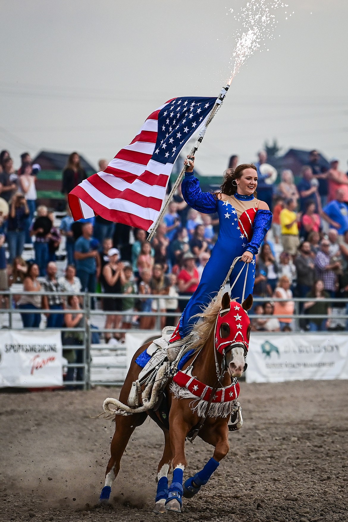 A rider holds the American flag during the opening ceremonies of the PRCA Rodeo at the Northwest Montana Fair & Rodeo on Thursday, Aug. 15. (Casey Kreider/Daily Inter Lake)