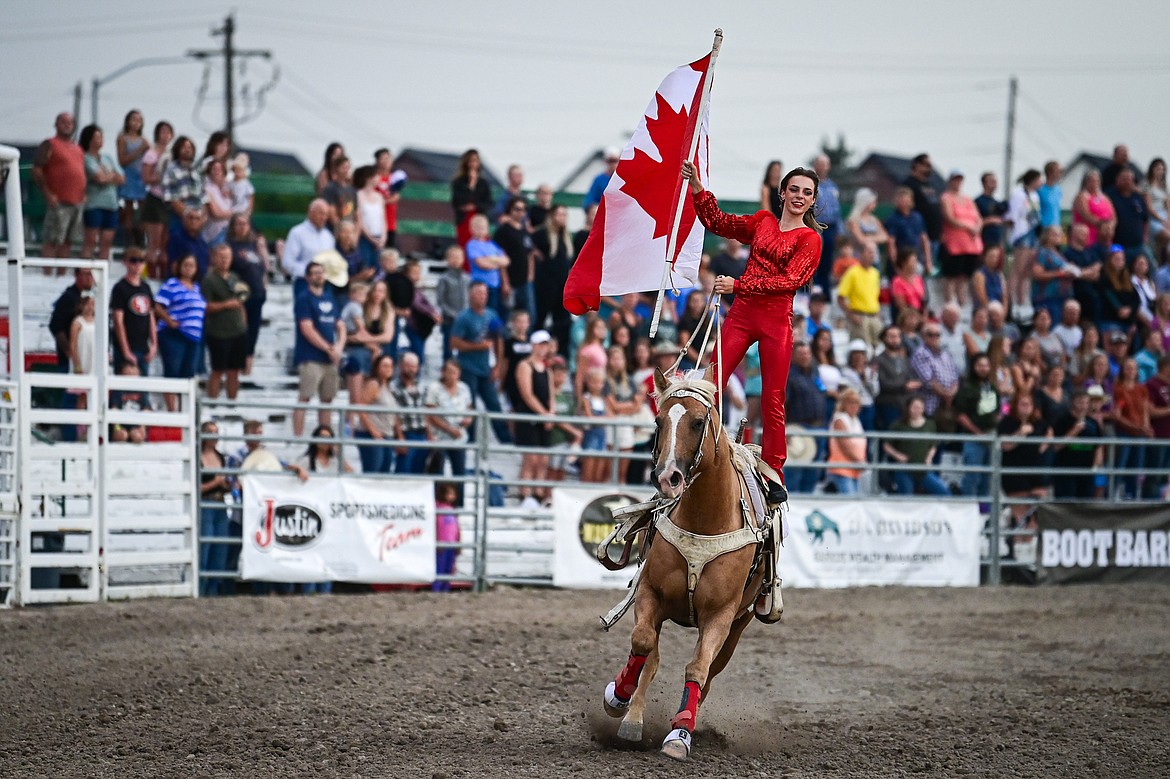 A rider holds the Canadian flag during the opening ceremonies of the PRCA Rodeo at the Northwest Montana Fair & Rodeo on Thursday, Aug. 15. (Casey Kreider/Daily Inter Lake)