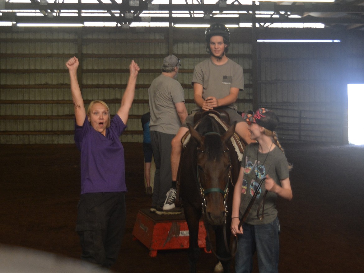 Diana Clemons celebrates Tanner Flinn getting a stuffed animal into a basket at Harmony Ranch.