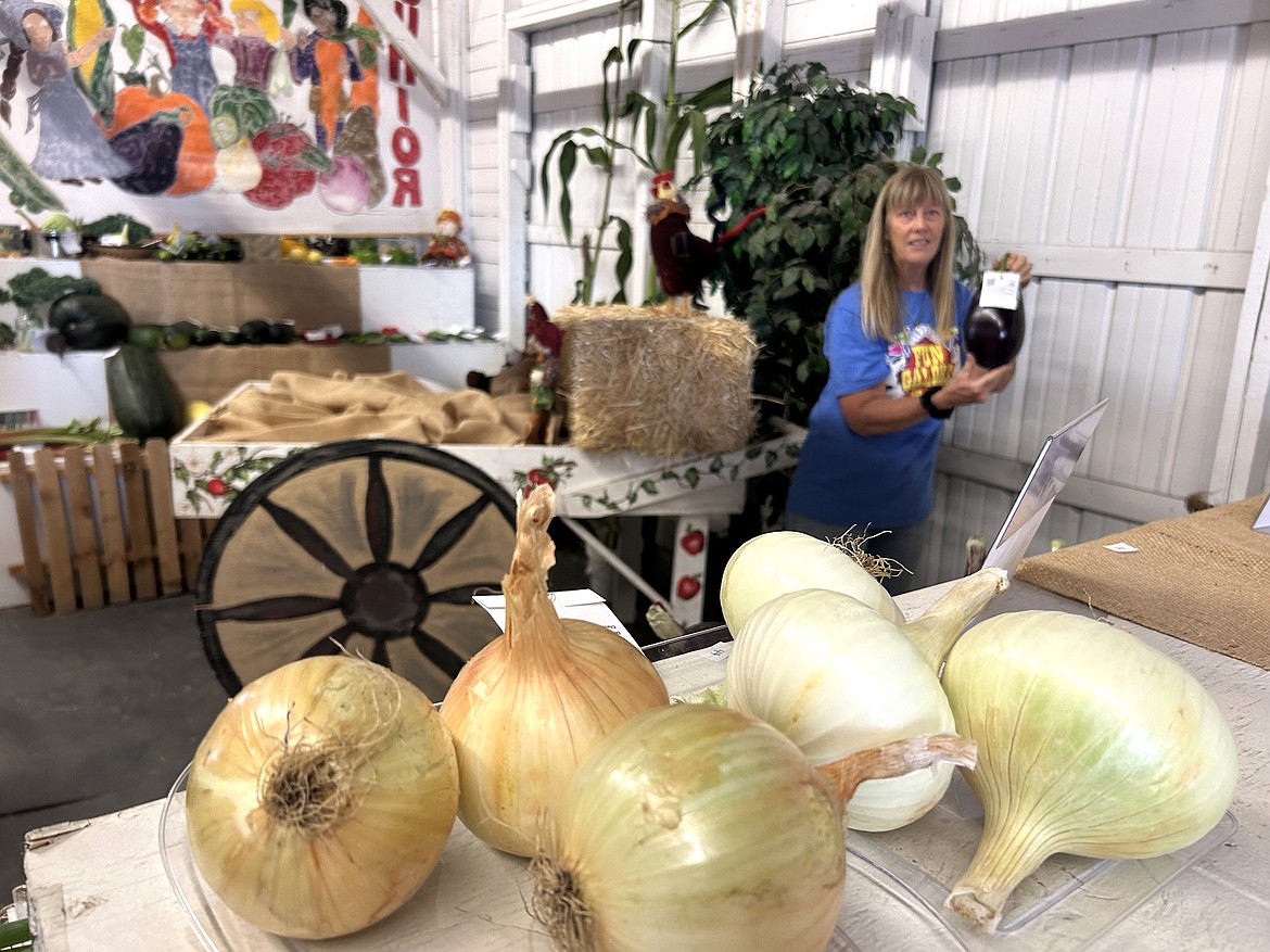 Lisa Houston holds an eggplant during preparations on Thursday for the North Idaho State Fair.