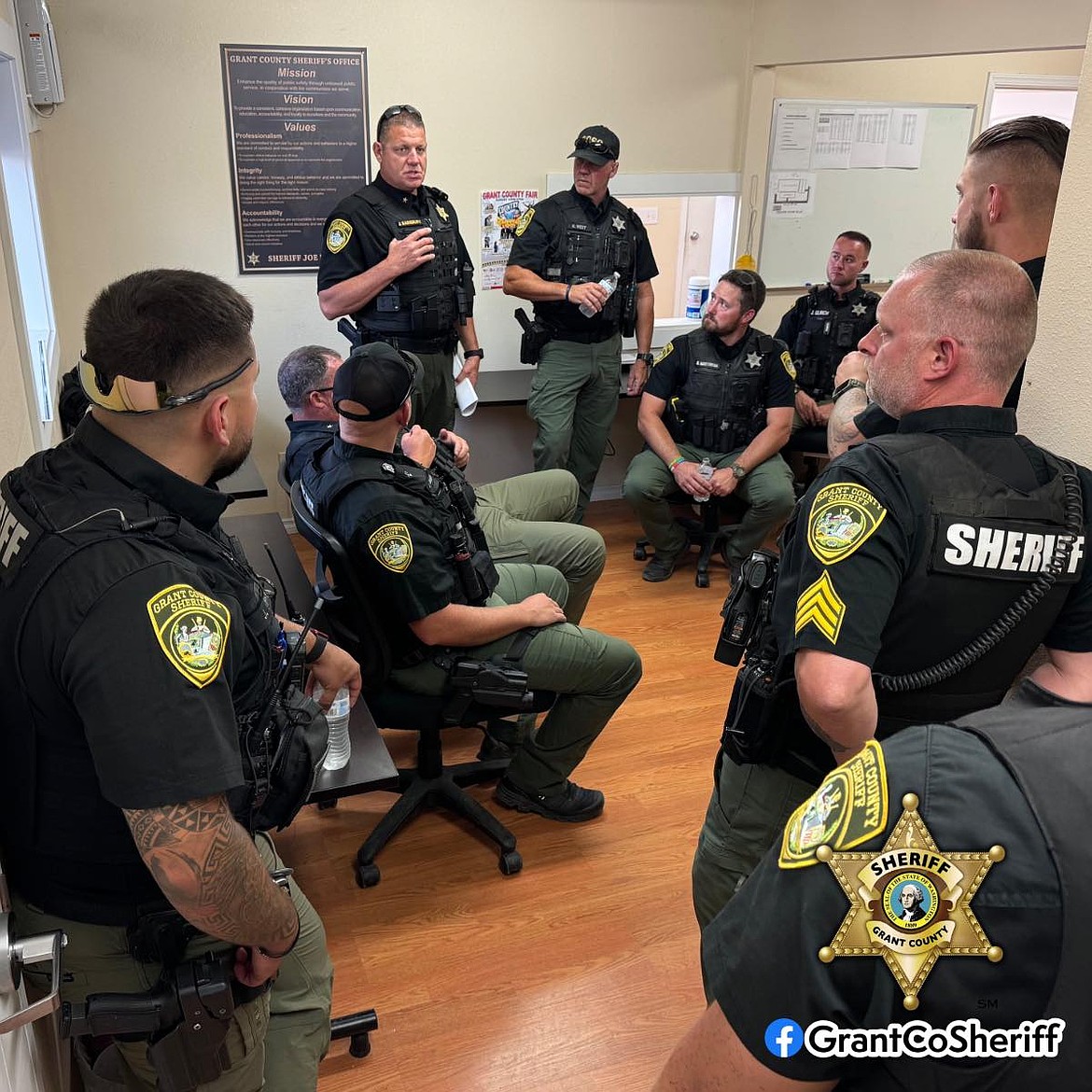 Grant County Sheriff's Office deputies receive a breifing before the evening shift at the Grant County Fair Tuesday. The fair has been relatively peaceful thus far.