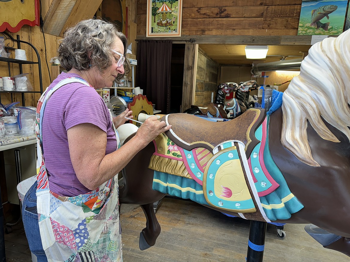 Wendy Lawrence paints the saddle on one of the Carousel of Smiles ponies.