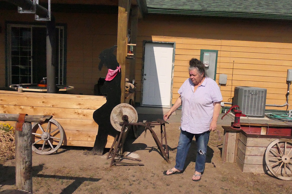 Pat Johnson with a 19th Century grinding wheel on display at the Wagon Wheel Saloon. (Chuck Bandel/VP-MI)