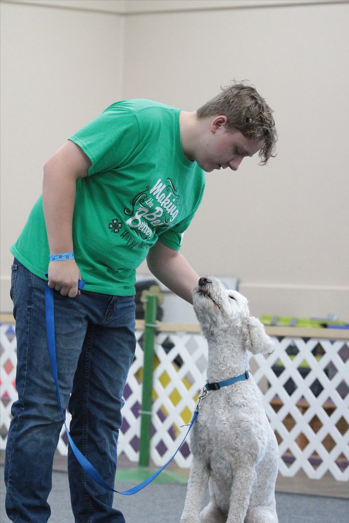 James Doyer pets his Goldendoodle, Ziva, after she finishes the first part of the obedience competition. Doyer has competed three times with Ziva and says she is improving.