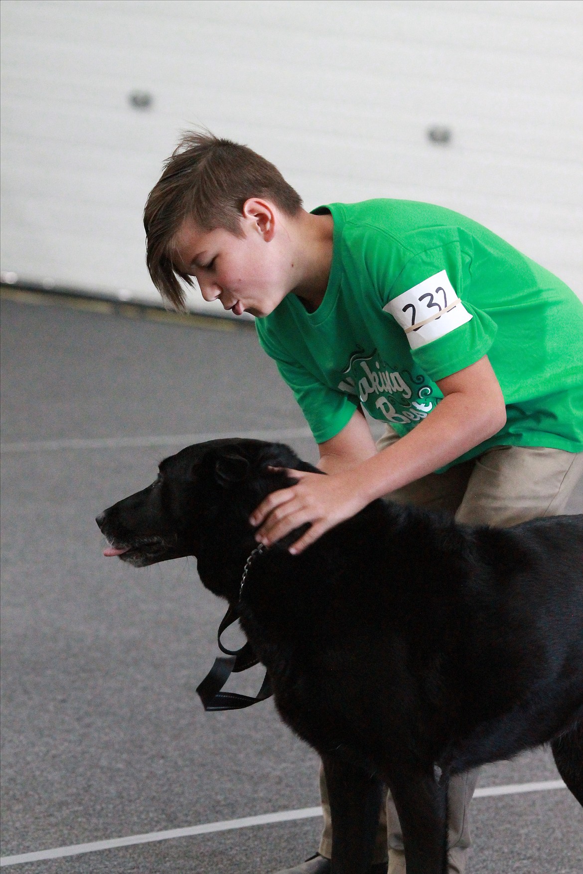 Rowan Spees pets and congratulates his black Labrador, Lucy after she completes part of the obedience competition. Lucy is the oldest dog that competed at 9 years old.