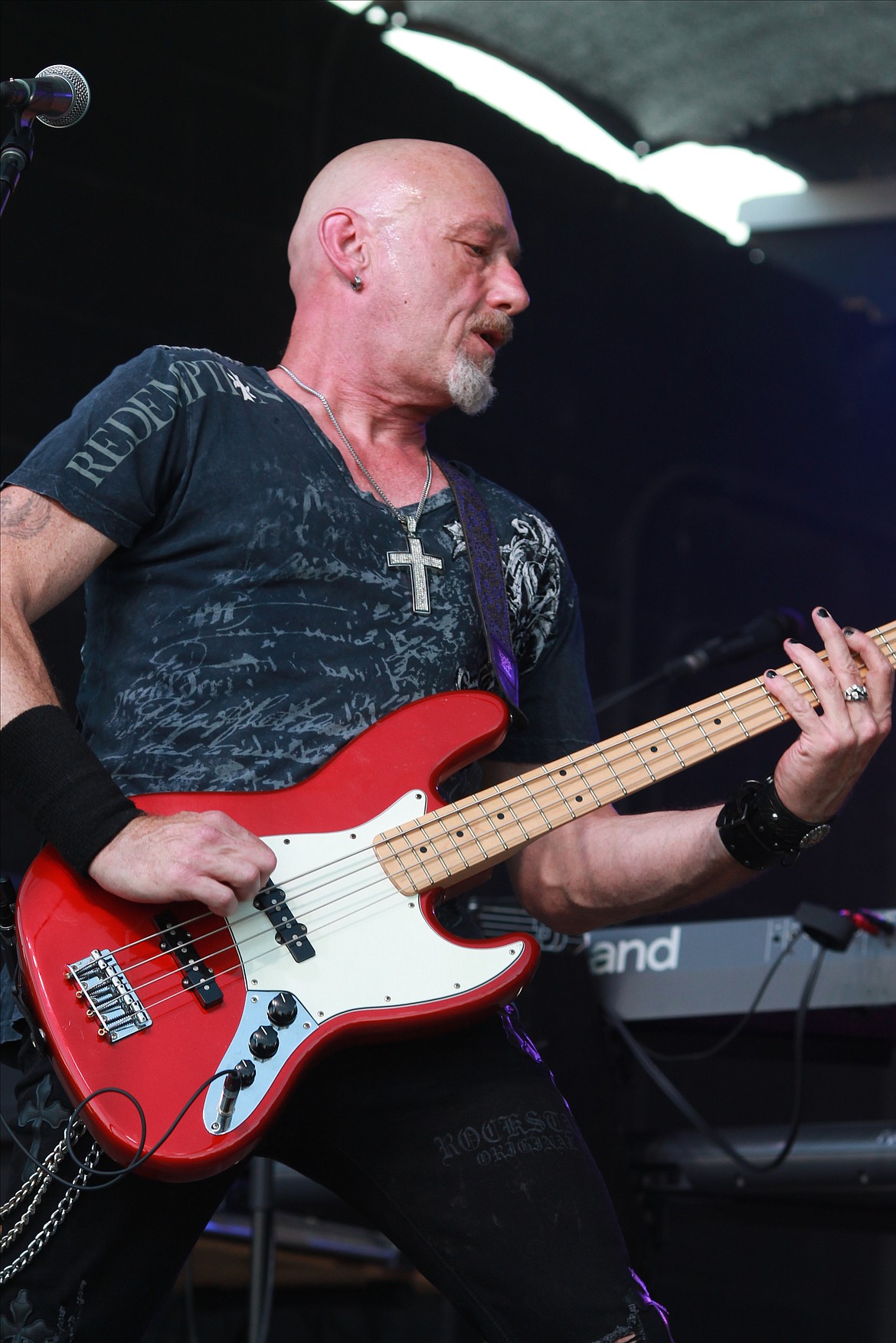 Mikey Knowles, the bassist for Crazy Train, an Ozzy Osbourne tribute band, shreds and sweats during the band's performance at the Grant County Fair.