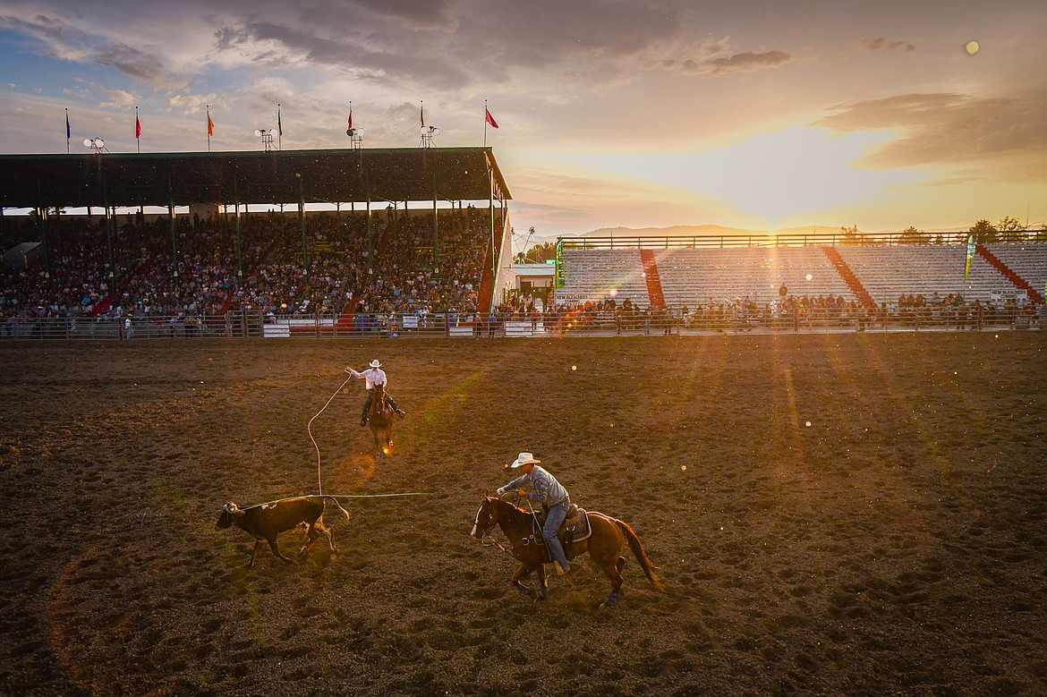 Alonzo Skunkcap, of Browning, and Nolan Conway, of Cut Bank, rope their steer during team roping as the sun shines through a light rain during the PRCA Rodeo at the Northwest Montana Fair & Rodeo on Thursday, Aug. 15. (Casey Kreider/Daily Inter Lake)