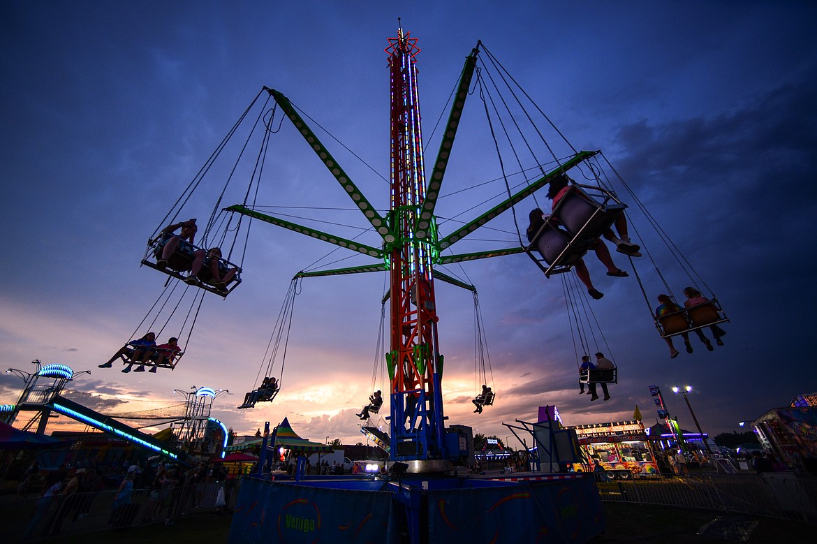 Riders are suspended at sunset on the Vertigo carnival ride at the Northwest Montana Fair & Rodeo on Thursday, Aug. 15. (Casey Kreider/Daily Inter Lake)