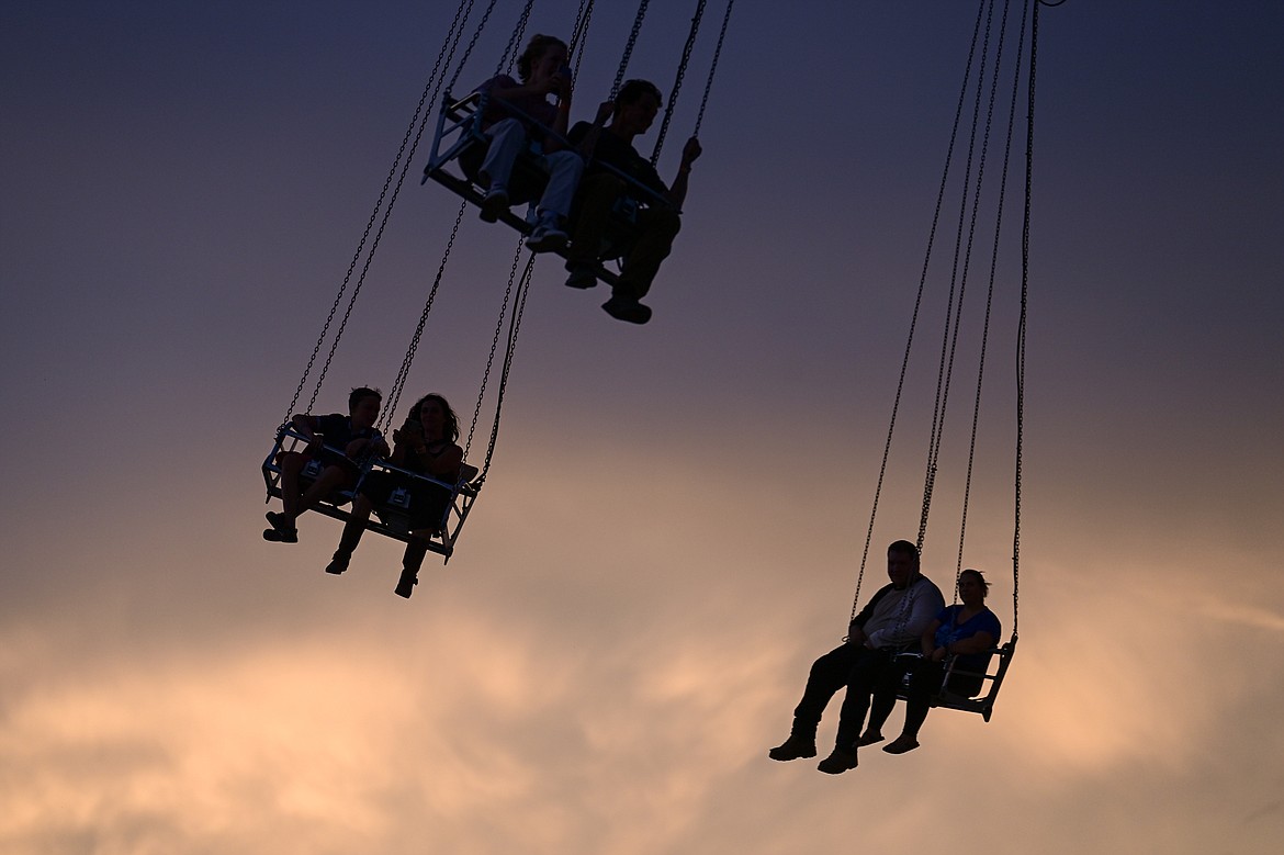 Riders swing at sunset on the Vertigo carnival ride at the Northwest Montana Fair & Rodeo on Thursday, Aug. 15. (Casey Kreider/Daily Inter Lake)