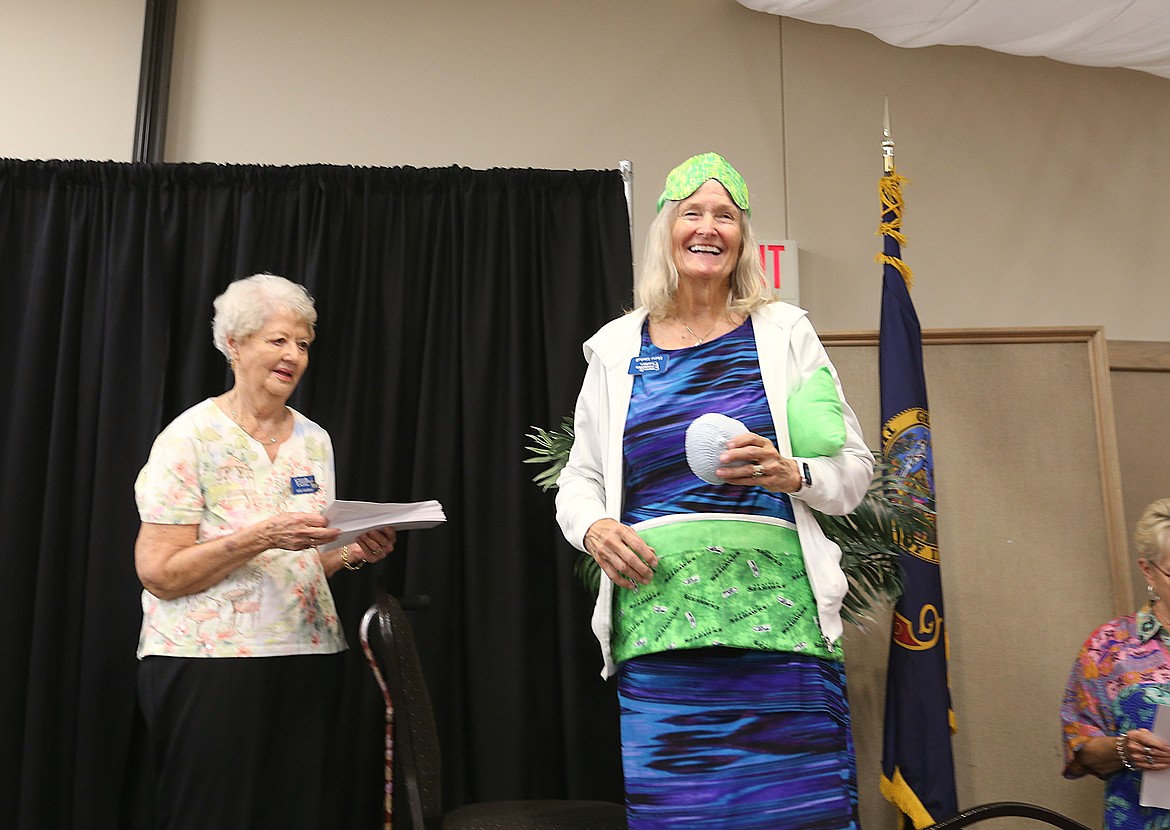 Elaine Kimball of Bag and Boob Babes, right, is seen with samples of comforting items her women's cancer nonprofit sews as she takes the stage Friday to accept a grant check from incoming Cancer and Community Charities President Judy Gardner. The 3Cs raised and gave away a record $135,000 this year.