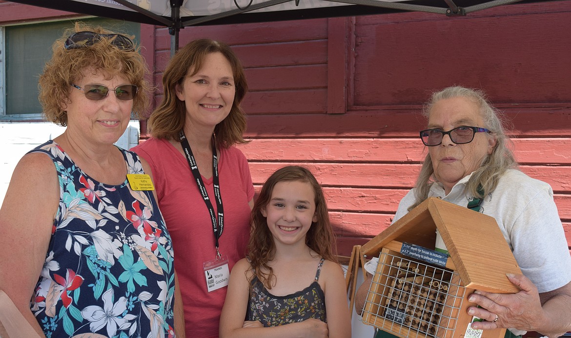 From left: Master Gardner Kathy Hernandez, trainee Maria Goodwin, Goodwin's granddaughter, Monroe Murphy, and Master Gardner Deborah Patterson. Patterson shows off a "bee house," a structure meant to provide a space for bees to build hives.